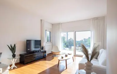 a living room with a white couch and a tv at ATHENS RIVIERA Grand Panoramic VILLAS I & II LAGONISSI in Kalívia Thorikoú