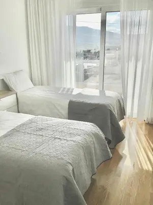 two beds in a hotel room with a large window at ATHENS RIVIERA Grand Panoramic VILLAS I & II LAGONISSI in Kalívia Thorikoú