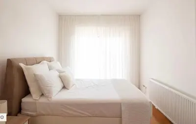 a bedroom with a bed with white pillows and a window at ATHENS RIVIERA Grand Panoramic VILLAS I & II LAGONISSI in Kalívia Thorikoú