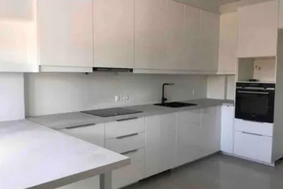 a kitchen with white cabinets and a black appliance at ATHENS RIVIERA Grand Panoramic VILLAS I & II LAGONISSI in Kalívia Thorikoú
