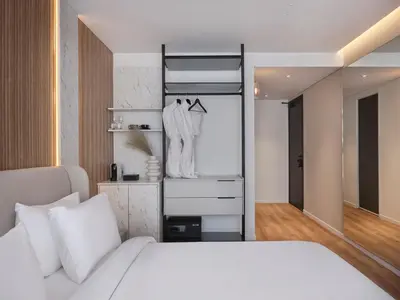 a bedroom with a white bed and a closet at Nur Aparthotel Athens in Athens