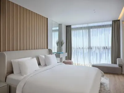 a white bedroom with a large bed and a couch at Nur Aparthotel Athens in Athens