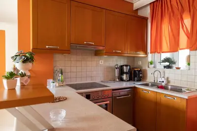 a kitchen with wooden cabinets and a counter top at Electra in Saronida