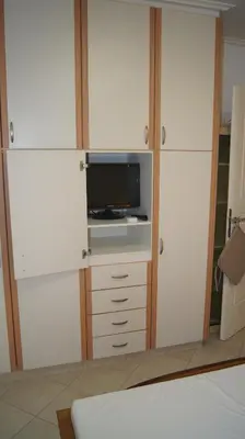 a room with white cabinets and a tv in it at Electra in Saronida
