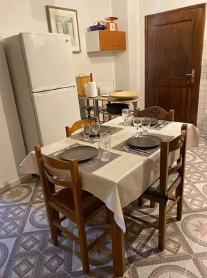 a table with chairs and a refrigerator in a kitchen at Apartment in Athens near Acropolis in Athens