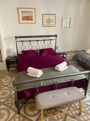 a bedroom with a bed with purple sheets and a chair at Apartment in Athens near Acropolis in Athens