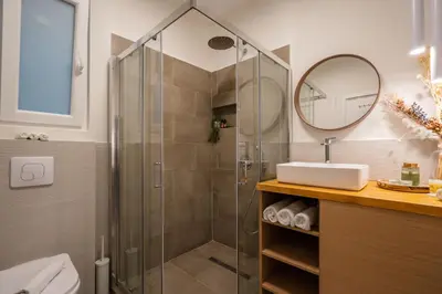 a bathroom with a shower and a sink and a mirror at Adela's Apartment BR & LR Next to Metro and 20' From Acropolis in Athens