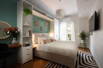 a bedroom with a bed and a desk and a television at Adela's Apartment BR & LR Next to Metro and 20' From Acropolis in Athens