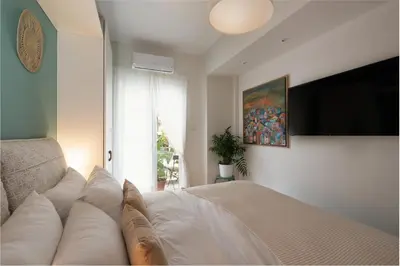 a bedroom with a bed and a flat screen tv at Adela's Apartment BR & LR Next to Metro and 20' From Acropolis in Athens