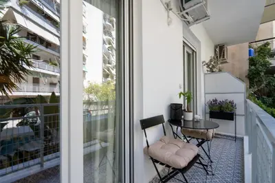 a balcony with a table and chairs next to a window at Adela's Apartment BR & LR Next to Metro and 20' From Acropolis in Athens