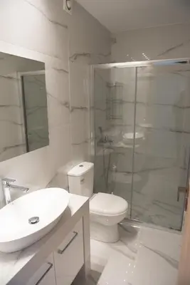 a white bathroom with a toilet and a glass shower at Newly renovated flat 500m from subway station (SKIATH_79) in Athens