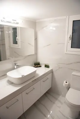 a white bathroom with a sink and a toilet at Newly renovated flat 500m from subway station (SKIATH_79) in Athens