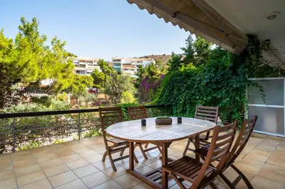 a patio with a table and chairs on a balcony at Vouliagmeni Honeymoon Suite by First Class Properties in Athens