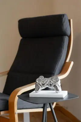 a black chair with a pair of silver shoes on a table at Vouliagmeni Honeymoon Suite by First Class Properties in Athens
