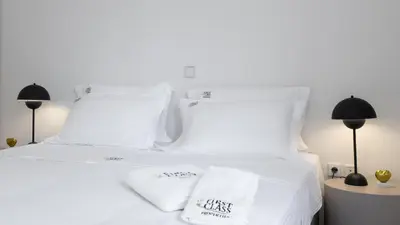 a white bed with two white pillows on it at Vouliagmeni Honeymoon Suite by First Class Properties in Athens