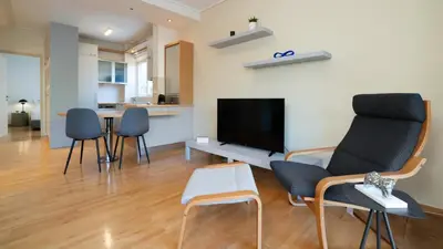 a living room with chairs and a flat screen tv at Vouliagmeni Honeymoon Suite by First Class Properties in Athens
