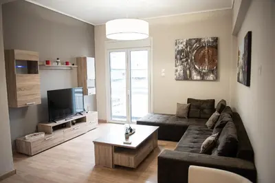 a living room with a couch and a tv at Spacious renovated flat 10min to metro station (KOL_71) in Athens