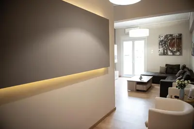 a living room with a wall with a light on it at Spacious renovated flat 10min to metro station (KOL_71) in Athens