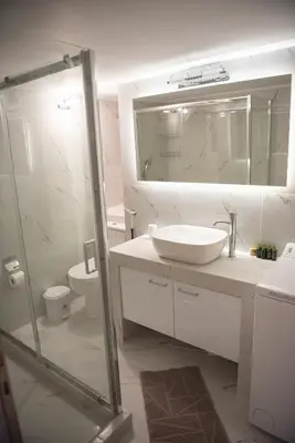 a bathroom with a sink and a toilet and a mirror at Spacious renovated flat 10min to metro station (KOL_71) in Athens