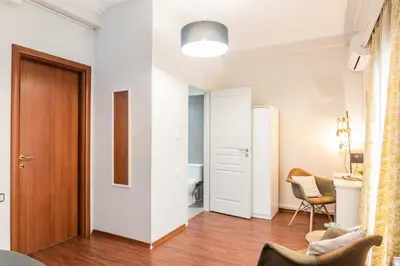 a living room with white walls and a wooden door at Beautiful City Rooms close to Acropolis in Athens