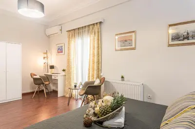 a living room with a bed and a table and chairs at Beautiful City Rooms close to Acropolis in Athens