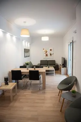 a living room with a couch and a table and chairs at Bright apartment 8min to metro station (KOL_25) in Athens