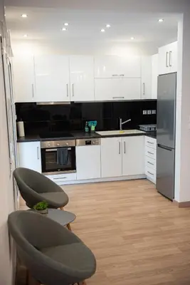 a kitchen with white cabinets and a stainless steel refrigerator at Bright apartment 8min to metro station (KOL_25) in Athens