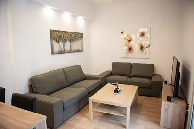 a living room with a couch and a table at Bright apartment 8min to metro station (KOL_25) in Athens