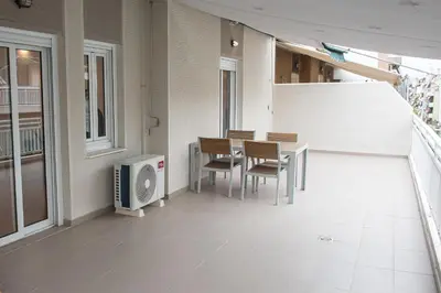 a room with a table and chairs and a tv at Bright apartment 8min to metro station (KOL_25) in Athens