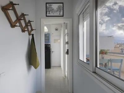 a hallway with a view of a room with a window at Cozy Loft with private terrace in the heart of Koukaki, Athens in Athens