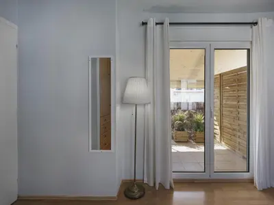 a white room with a glass door and a lamp at Cozy Loft with private terrace in the heart of Koukaki, Athens in Athens