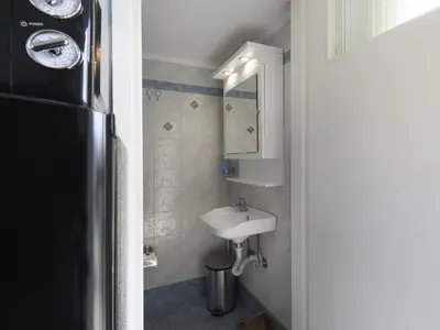 a small bathroom with a sink and a mirror at Cozy Loft with private terrace in the heart of Koukaki, Athens in Athens