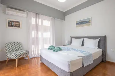 a bedroom with a large bed and a chair at Andromar in the heart of Kolonaki in Athens