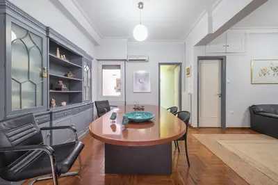 a living room with a wooden table and chairs at Andromar in the heart of Kolonaki in Athens