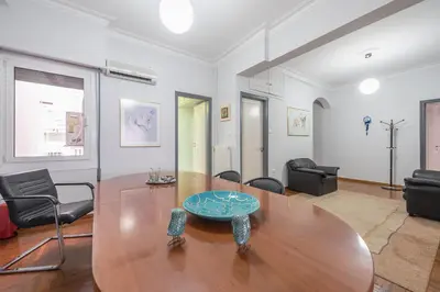 a living room with a wooden table and chairs at Andromar in the heart of Kolonaki in Athens