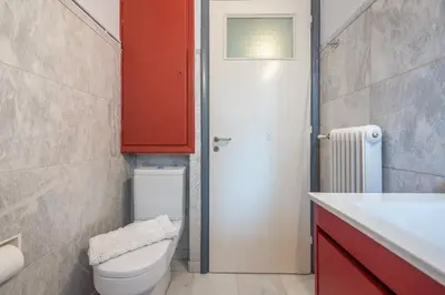 a bathroom with a toilet and a red door at Andromar in the heart of Kolonaki in Athens