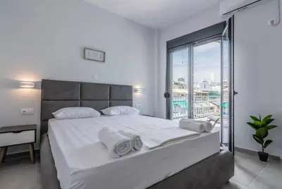 a bedroom with a large bed with white sheets and pillows at Garden of Eden in Koukaki in Athens
