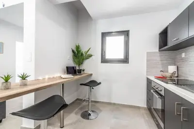 a kitchen with a counter and a stool in a room at Garden of Eden in Koukaki in Athens