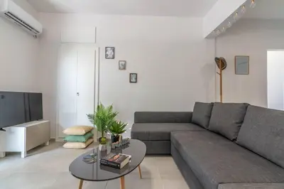 a living room with a gray couch and a table at Garden of Eden in Koukaki in Athens