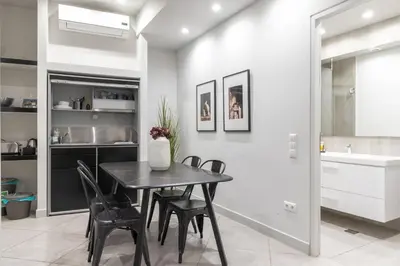 a dining room with a black table and chairs at Fantastic Central Athens Suite with shared Rooftop Deck in Athens