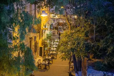 a view of a street with tables and chairs at night at Fantastic Central Athens Suite with shared Rooftop Deck in Athens