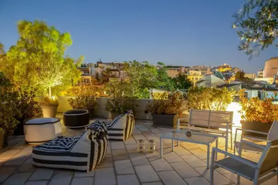 a group of chairs and tables on a patio at Fantastic Central Athens Suite with shared Rooftop Deck in Athens