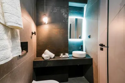 a bathroom with a sink and a mirror at CASA DIVINUS SUITES in Athens