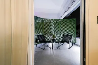 a balcony with chairs and a table in a building at CASA DIVINUS SUITES in Athens