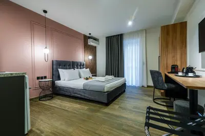 a hotel room with a bed and a desk at CASA DIVINUS SUITES in Athens