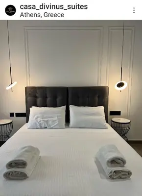a bedroom with a large bed with towels on it at CASA DIVINUS SUITES in Athens
