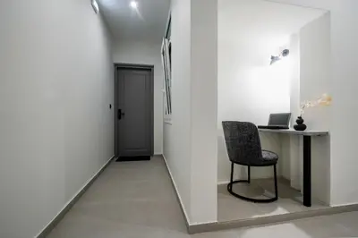 a hallway with a chair and a desk and a door at CASA DIVINUS SUITES in Athens