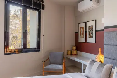 a bedroom with a bed and a chair and a window at Entire Building in the Heart of Athens Sleeps 15 with Private Rooftop Terrace in Athens