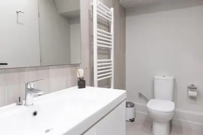 a white bathroom with a toilet and a sink at Entire Building in the Heart of Athens Sleeps 15 with Private Rooftop Terrace in Athens