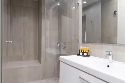 a bathroom with a shower and a sink and a mirror at Entire Building in the Heart of Athens Sleeps 15 with Private Rooftop Terrace in Athens